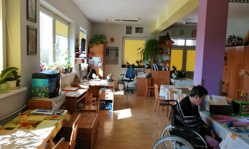 Zdjęcie przedstawia widok sali terapii zajęciowej. Widzimy tutaj dużą liczbę krzeseł oraz stolików