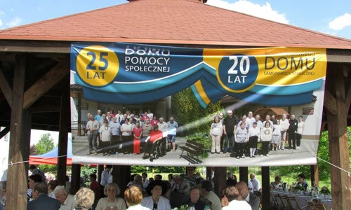 Na zdjęciu widać altankę która jest przystrojona plakatem na uroczystość 25 lecia domu